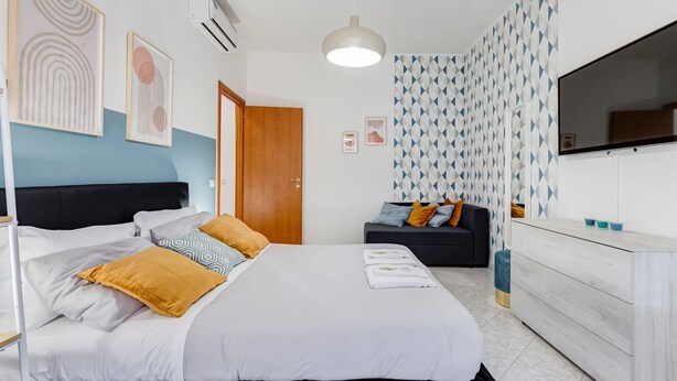 A modern bedroom with a bed, a sofa, a TV, and a wardrobe. - Apartment Vaticana - Two Bedroom Villa, Sleeps 6 (Rome)