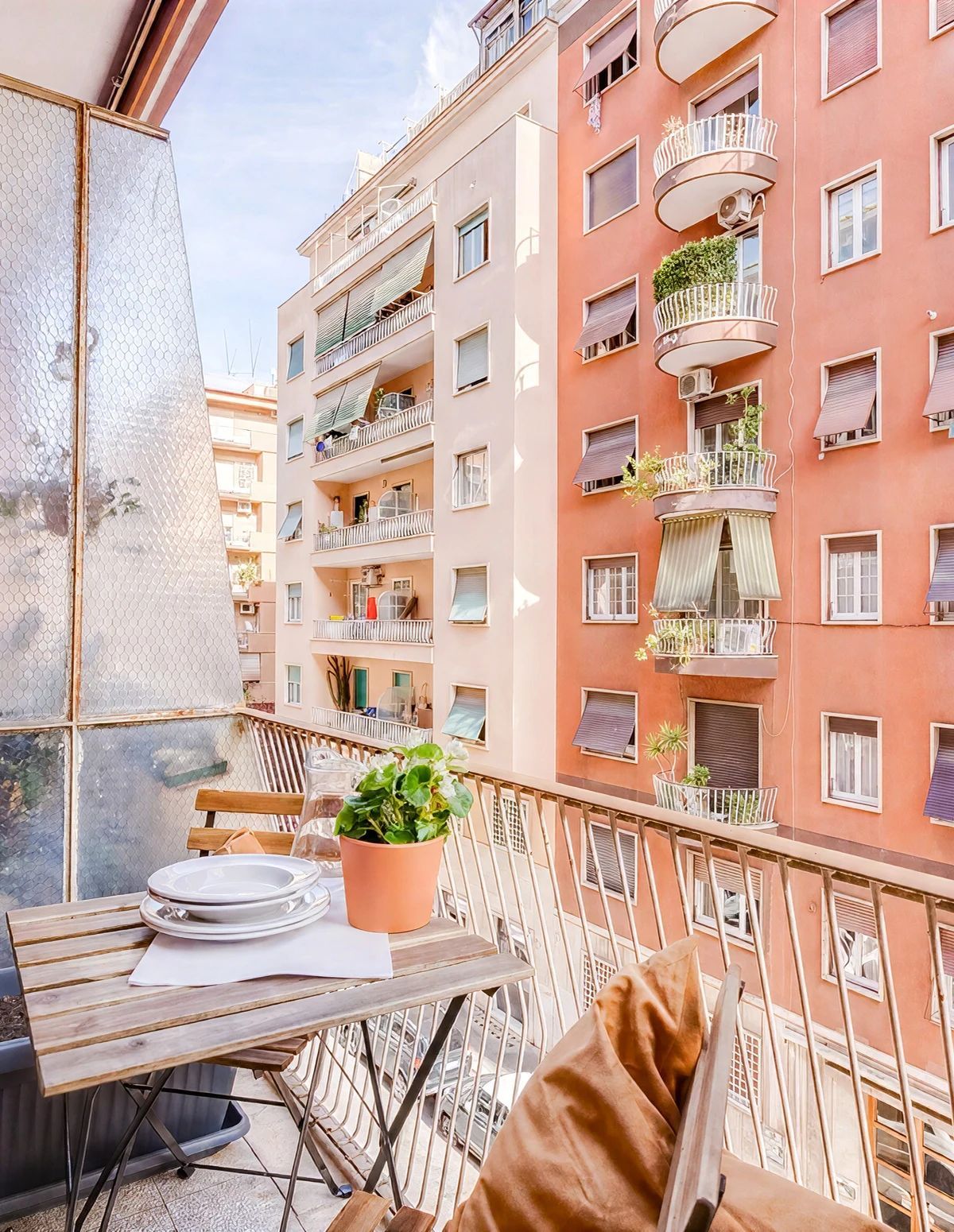 Parveke, jossa on pöytä, tuoleja ja ruukussa oleva kasvi.