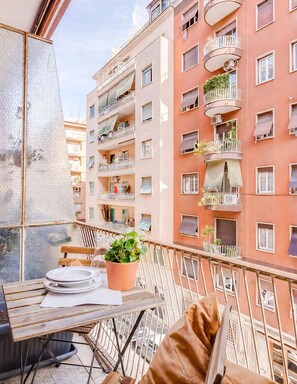 Ein Balkon mit Tisch, Stühlen und einem Blumentopf.