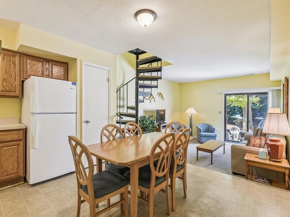Cocina compacta con comedor, una escalera de caracol y vistas al exterior.