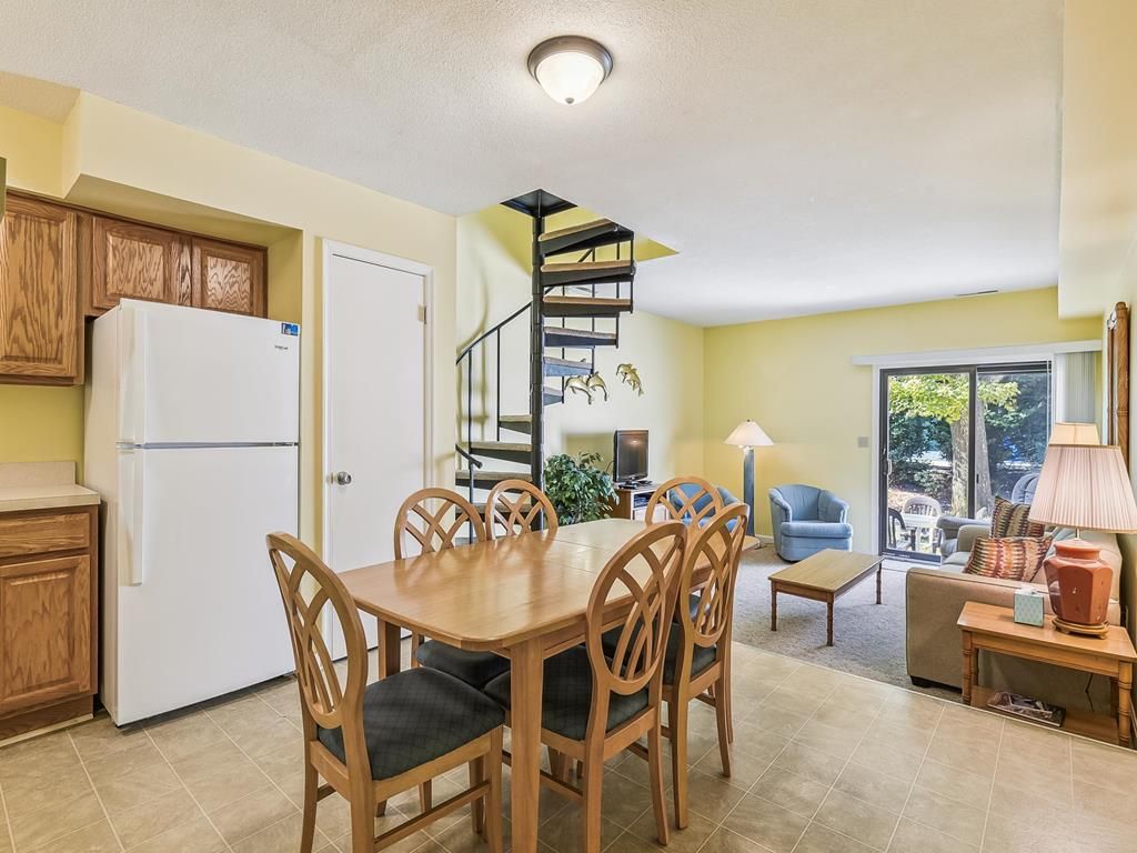 Una cocina compacta con comedor, una escalera en espiral y vistas al exterior.
