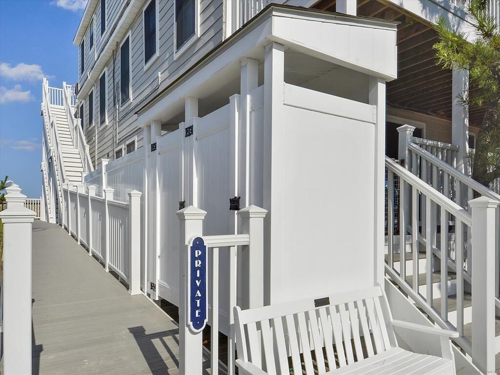 A private residential building with a wooden deck and a staircase leading to the entrance.