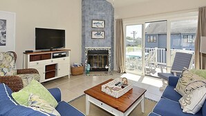 A living room with a TV, fireplace, and seating area.