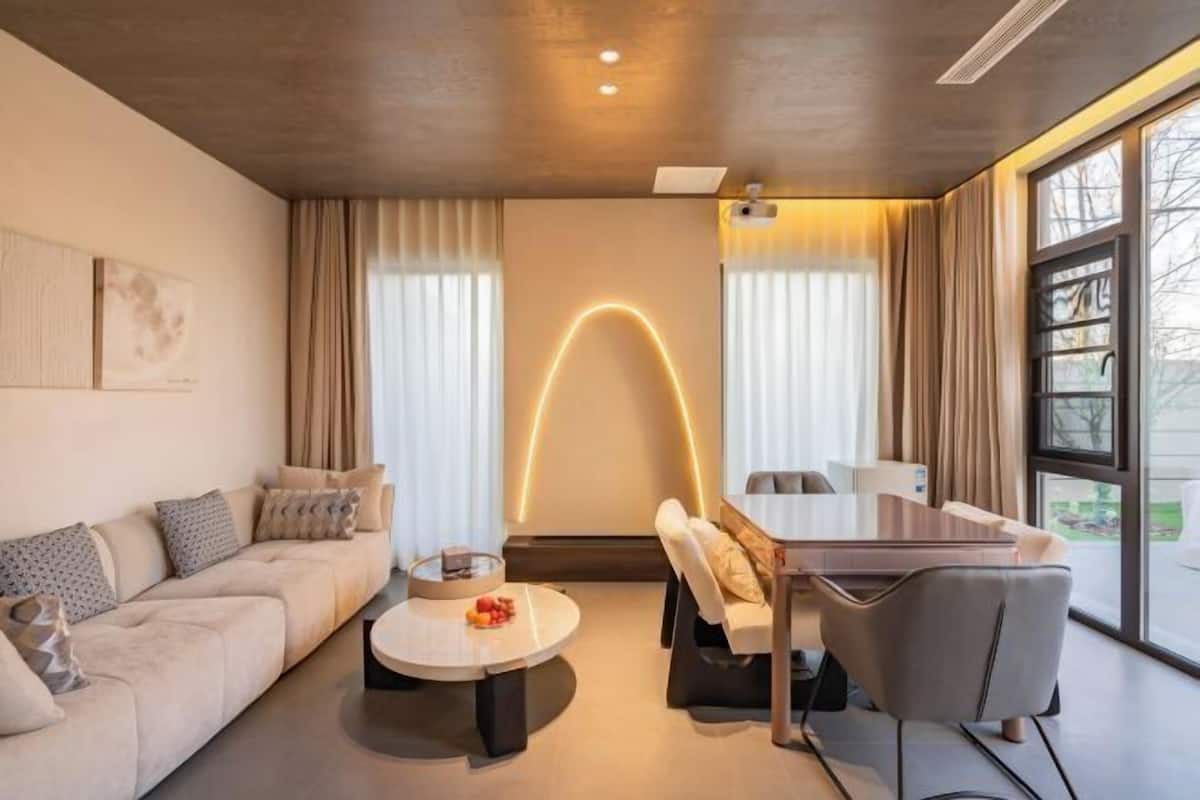 Uma sala de estar moderna com sofá, mesa de centro e área de jantar.