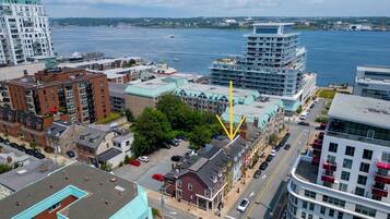 A high-rise hotel with multiple floors, a parking lot, and a view of the waterfront.