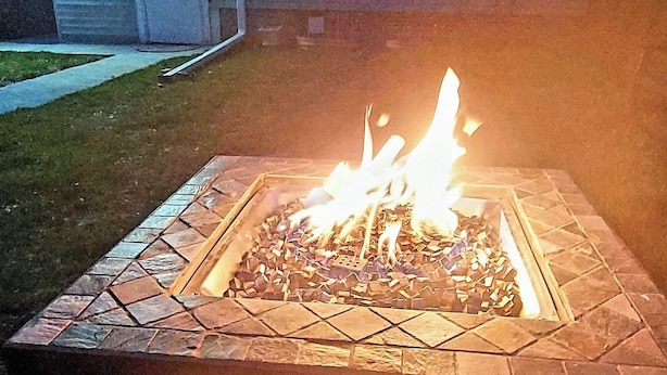A fire pit with flames, surrounded by a stone border, in an outdoor setting with a building in the background. - Spacious 4-bedroom apartment in fabulous Milwaukee with WiFi, AC, onsite Parking (Milwaukee)