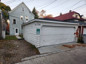 Un garaje residencial con un letrero que dice 'Solo Residentes Autorizados', el número '2744' en la puerta del garaje y un techo rojo en una casa vecina.