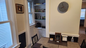 A dining area with a table, chairs, a clock, and a 'Welcome' sign. - Spacious 4-bedroom apartment in fabulous Milwaukee with WiFi, AC, onsite Parking (Milwaukee)