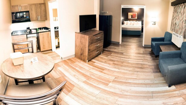 Een moderne hotelkamer met een keuken, een eethoek en een zithoek.