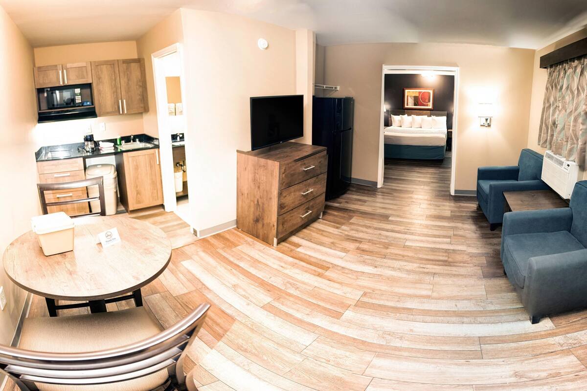 Quarto de hotel moderno com cozinha, sala de jantar e sala de estar.
