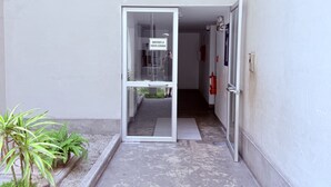 A building entrance with a glass door, a sign instructing to keep the door closed, and a number '2' above the door.