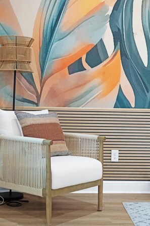 A modern living room with a rattan chair, a patterned throw pillow, and a floor lamp. - Family Retreat, Fire Pit, Games, Close to Ft Moore (Columbus)