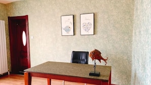 Une pièce avec une table en bois, une sculpture de poisson et deux tableaux encadrés accrochés au mur.