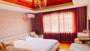 Une chambre avec un grand lit, un plafond en bois et une fenêtre avec des rideaux.