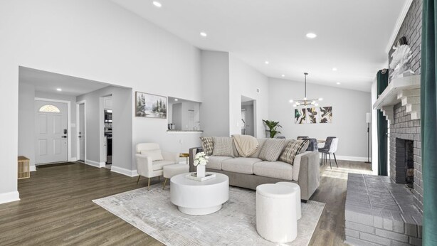 A spacious living room with a modern fireplace, a round coffee table, and a sofa.