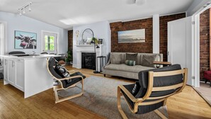 A modern living room with a fireplace, a dining area, and a kitchen. - Historic 2 bedroom central down town location near waterfront - #3 (Halifax)