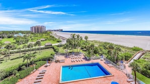 A resort with a swimming pool, beach, and palm trees. - Beachfront Condo With Pool, Tennis and Fitness Center (Marco Island)