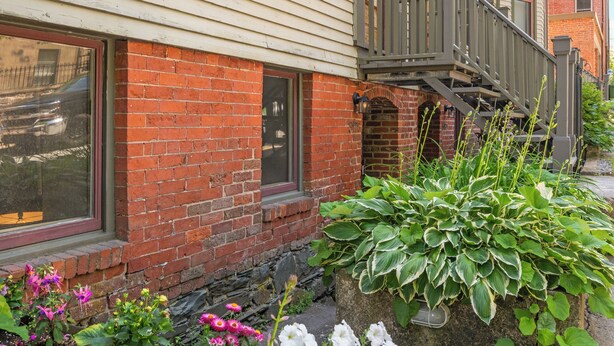 A two-story building with a brick facade and a wooden deck. - Halifax Old South District Library Suite (Halifax)