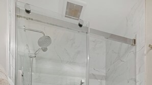 A glass-enclosed shower with a handheld showerhead and a wall-mounted faucet. - Halifax Old South District Library Suite (Halifax)