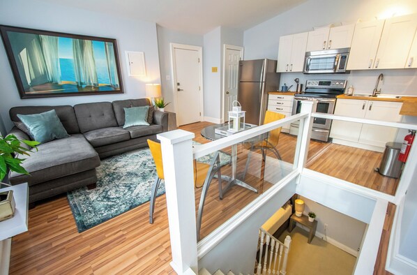 A modern apartment with a living room, kitchen, and balcony.