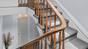Eine Treppe mit hölzernen Spindeln und einem Teppich belagten Podest.