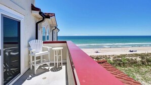 Un balcon avec vue sur la plage et l’océan.