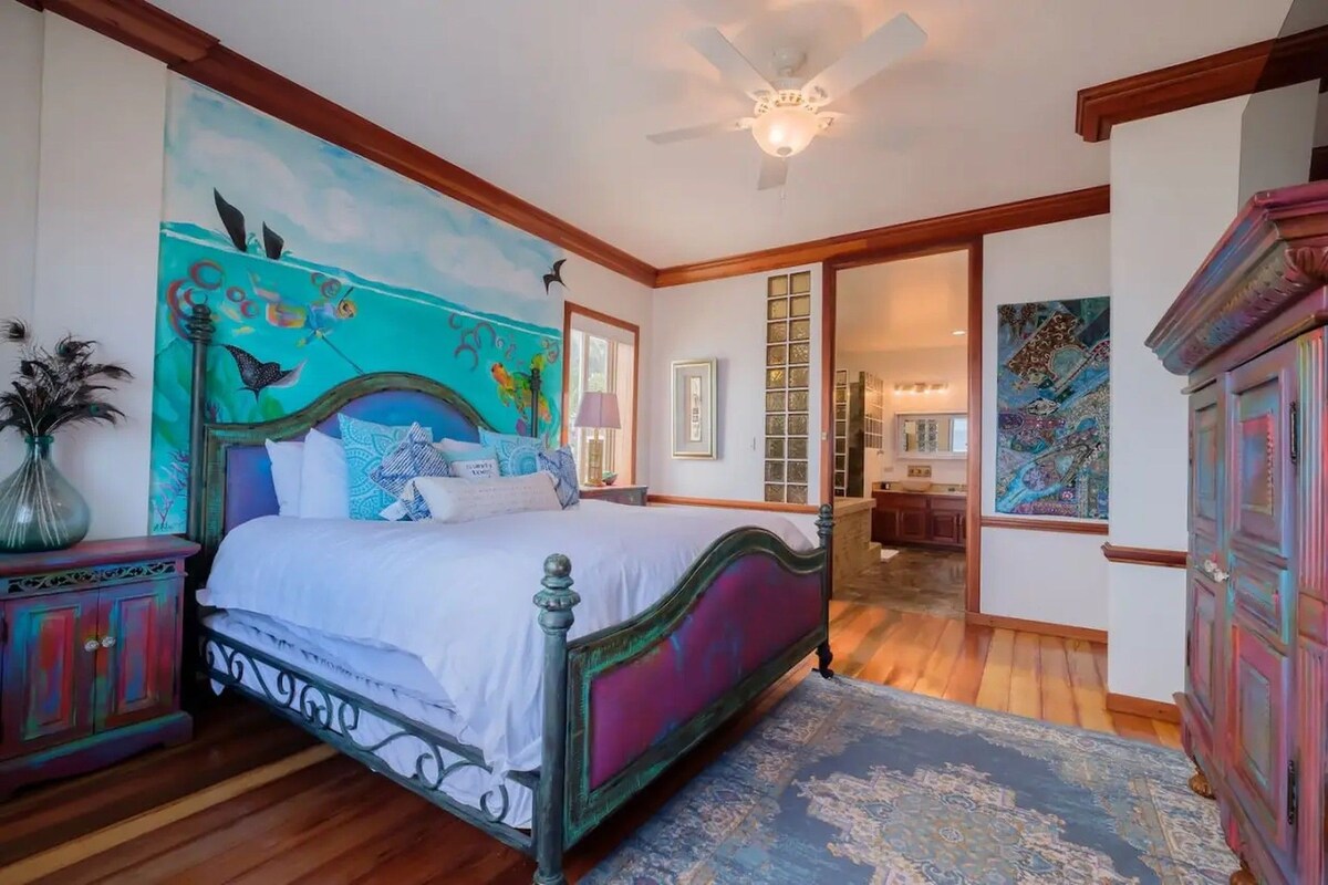 A bedroom with a bed, a nightstand, a dresser, and a ceiling fan.