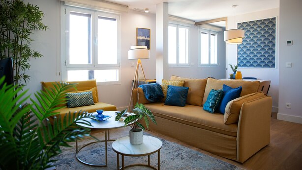 Ein modernes Wohnzimmer mit einer Couch, einem Couchtisch und einer Stehlampe.