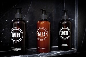 Three bottles of MB products on a marble surface.