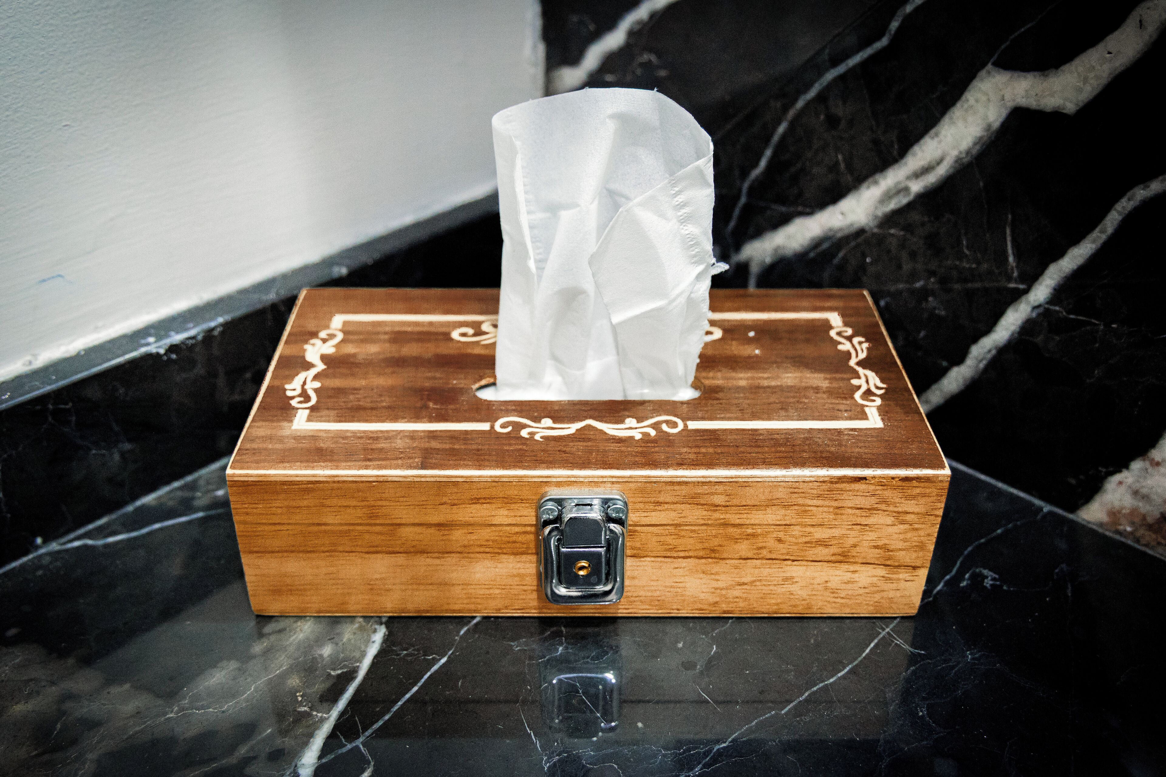A tissue box with a lock on a marble surface.