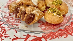 A variety of traditional Italian breakfast pastries on a table with a red and white patterned tablecloth.