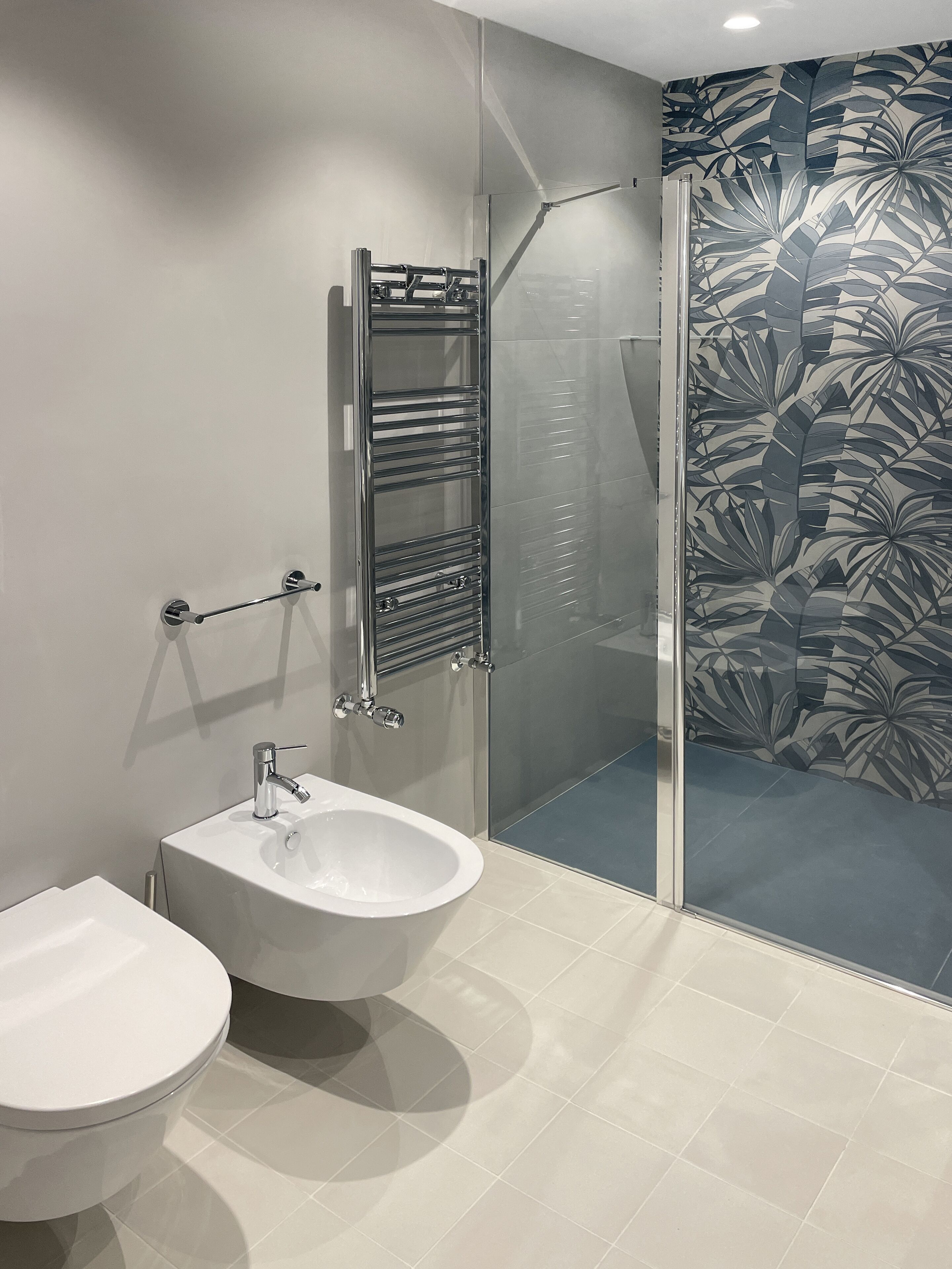 Ein modernes Badezimmer mit Duschkabine aus Glas, einem weißen Waschbecken und einer Toilette.