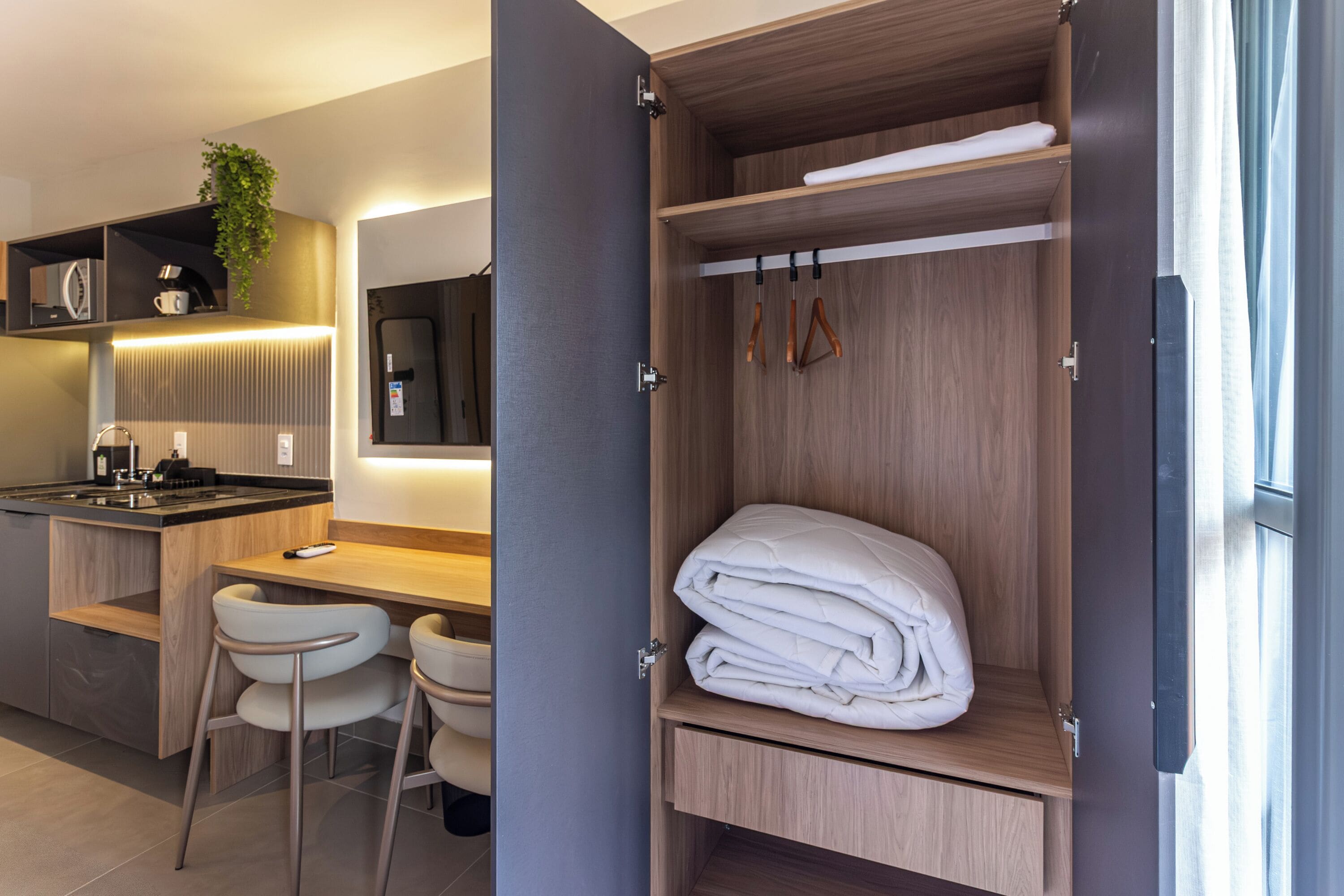 A modern kitchen with a built-in stove, a bar area, and a seating space with chairs.