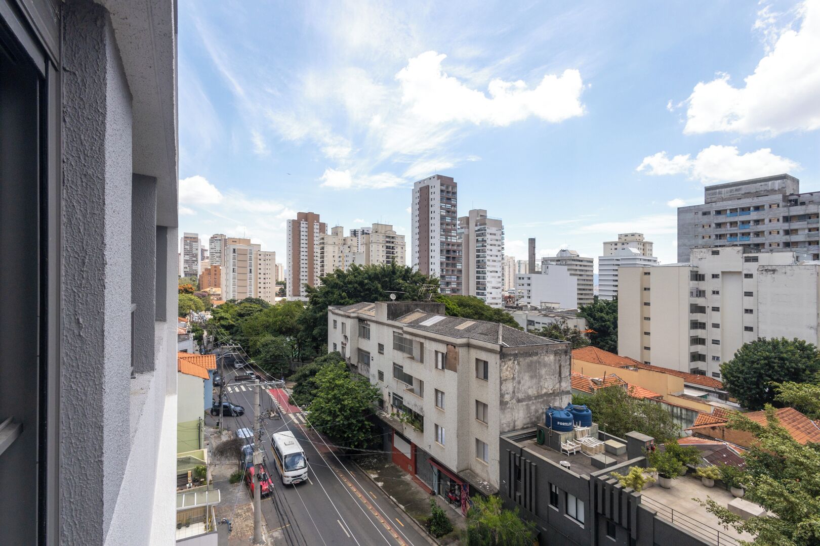A cityscape with tall buildings, a street with vehicles, and a mix of residential and commercial structures.