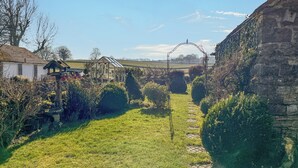 A rural landscape with a stone archway, a glass greenhouse, and a white building. - 3 bedroom accommodation in Monyash, near Bakewell (Monyash, near Bakewell)