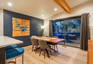 Een eetgedeelte met een tafel, stoelen en een kaart aan de muur.