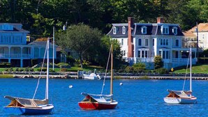 A waterfront with sailboats and a large house with a porch. - Charming Walk to downtown Mystic Awaits Your Stay (Mystic)