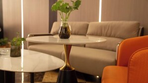 A modern living room with a round table, a sofa, and a potted plant. - Lishan Yizhai Inn (Xi'an)