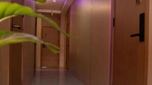 A hallway with wooden doors, a marble floor, and a plant in the foreground. - Lishan Yizhai Inn (Xi'an)