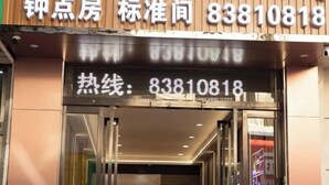 A hotel entrance with a digital display showing the phone number 83810818. - Lishan Yizhai Inn (Xi'an)