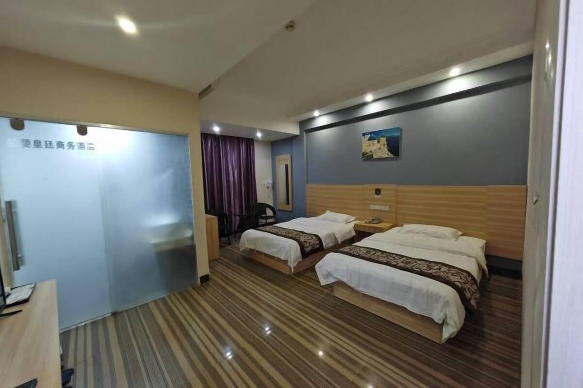 Una habitación de hotel con dos camas, un escritorio, una silla y una cortina.