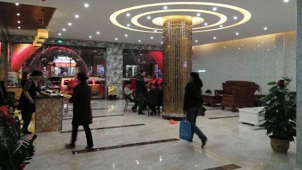 Un hall d’entrée avec une colonne centrale, des espaces d’attente et un comptoir d’accueil.