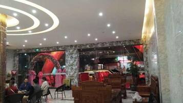 Eine Hotelhalle mit Marmorböden, Sitzbereichen und einer Rezeption.