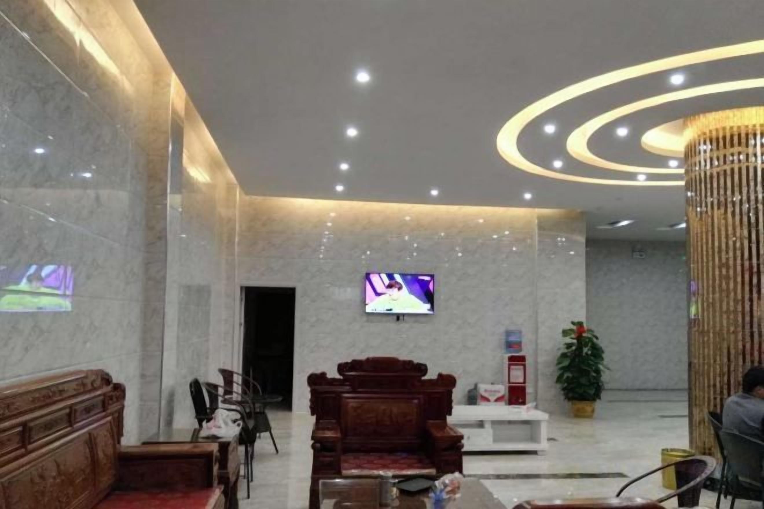 A lobby with a TV, seating area, and a decorative column.
