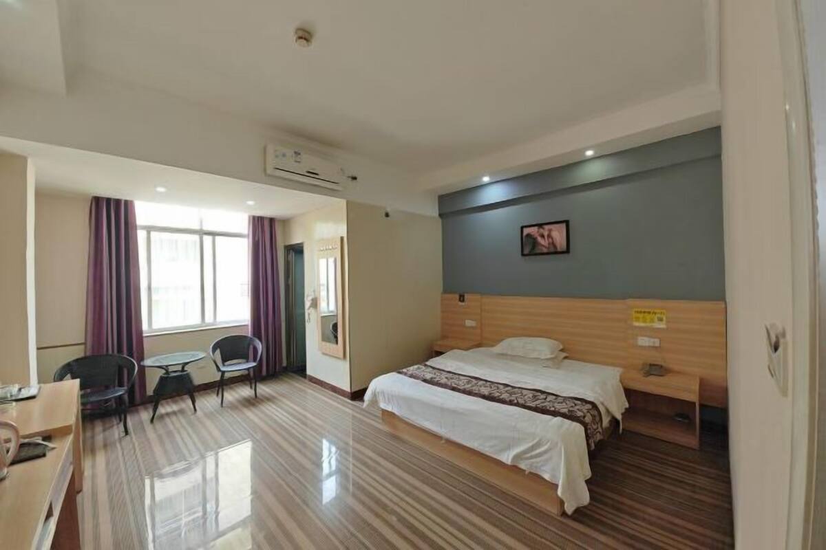 Una habitación de hotel con cama, escritorio, silla y una mesita.