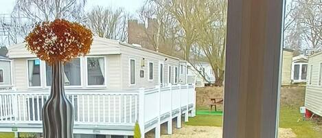 A row of mobile homes with white exteriors and a white fence.