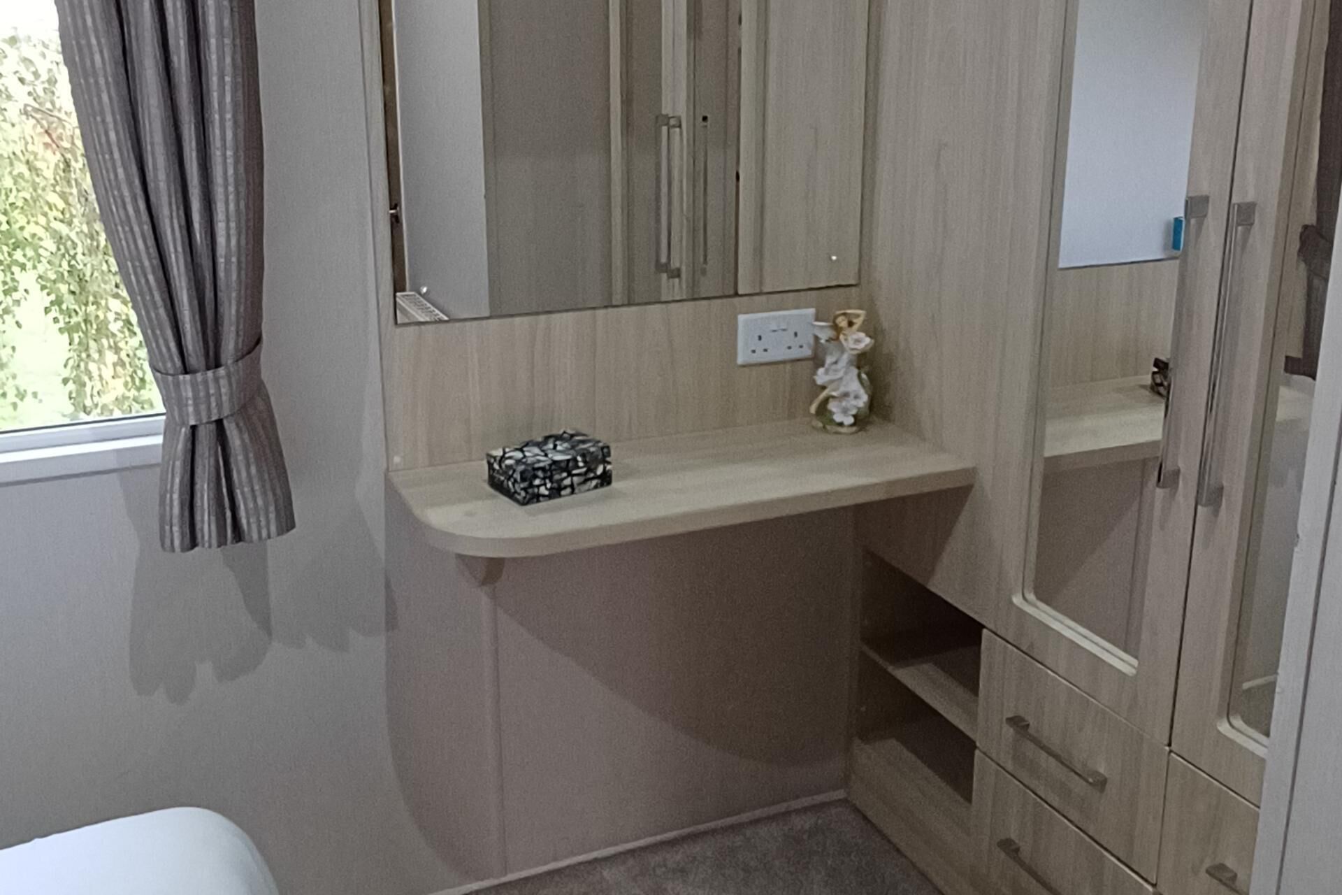Une chambre à coucher avec un lit, une table de chevet, un miroir et une armoire.