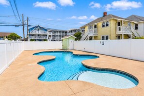 A swimming pool with a wavy edge, surrounded by a white fence, with houses in the background. - Coastal-Chic · Pool, Bay View & Balcony·Walk2Beach (Ocean City)