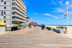 A boardwalk with a wooden walkway, buildings on one side, and a beach on the other. - Coastal-Chic · Pool, Bay View & Balcony·Walk2Beach (Ocean City)