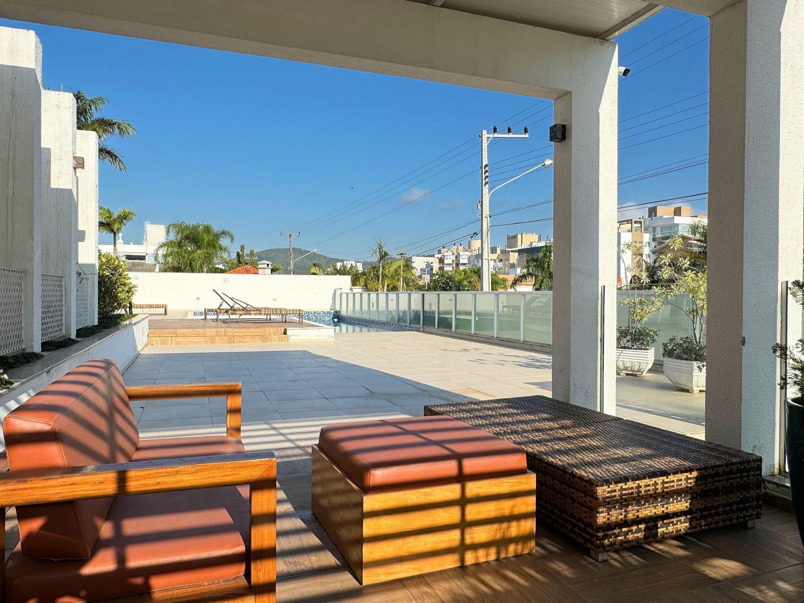 An outdoor seating area with wooden furniture and a view of the cityscape.